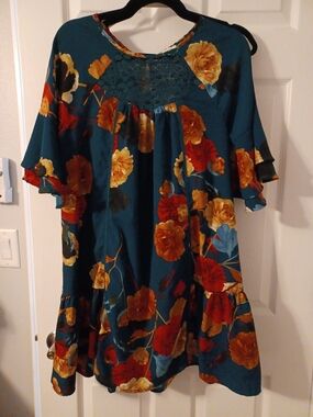 Umgee teal tunic dress features a vibrant floral print and ruffle sleeves.